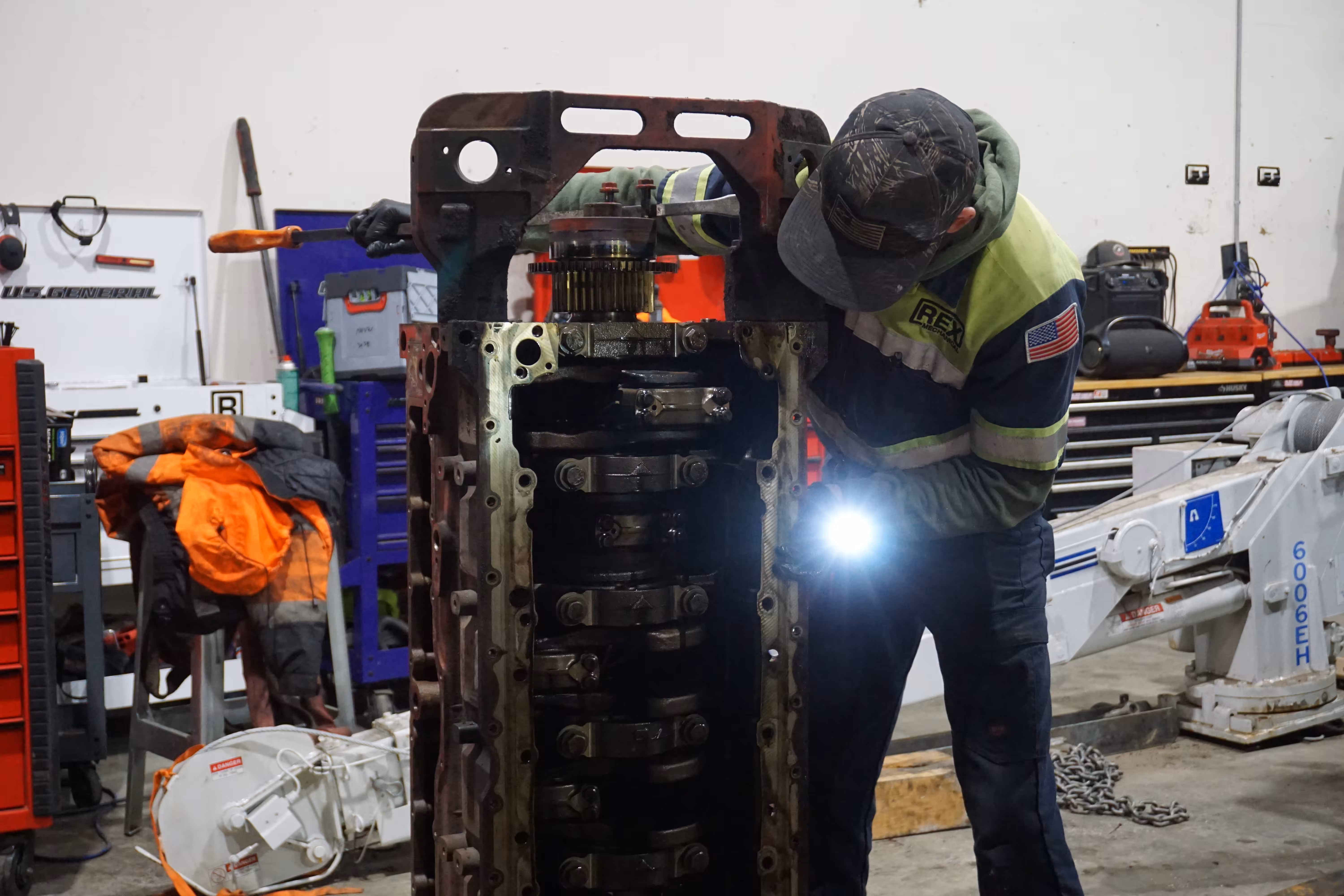 A technician inspects the main bearing caps of a diesel engine block